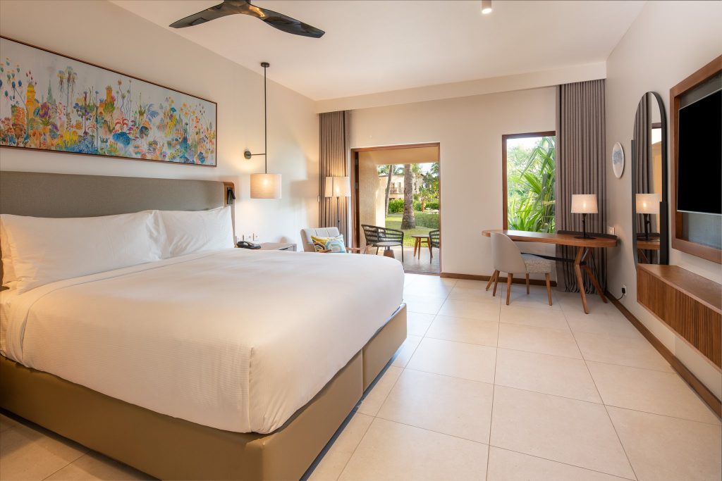 Modernes King Deluxe Room Zimmer im Hilton Mauritius Resort & Spa mit Holzmöbeln, Terrasse und Gartenblick