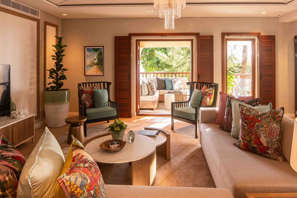 Wohnbereich der Presidential Suite im Hilton Mauritius Resort & Spa mit Sofa, Sesseln, Holzboden und Balkonblick