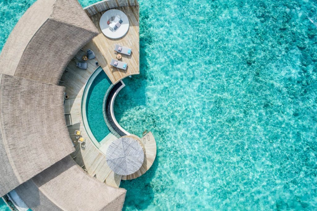 Vogelperspektive auf Two Bedroom Overwater Pool Residence mit Holzterrasse und türkisfarbenem Wasser auf den