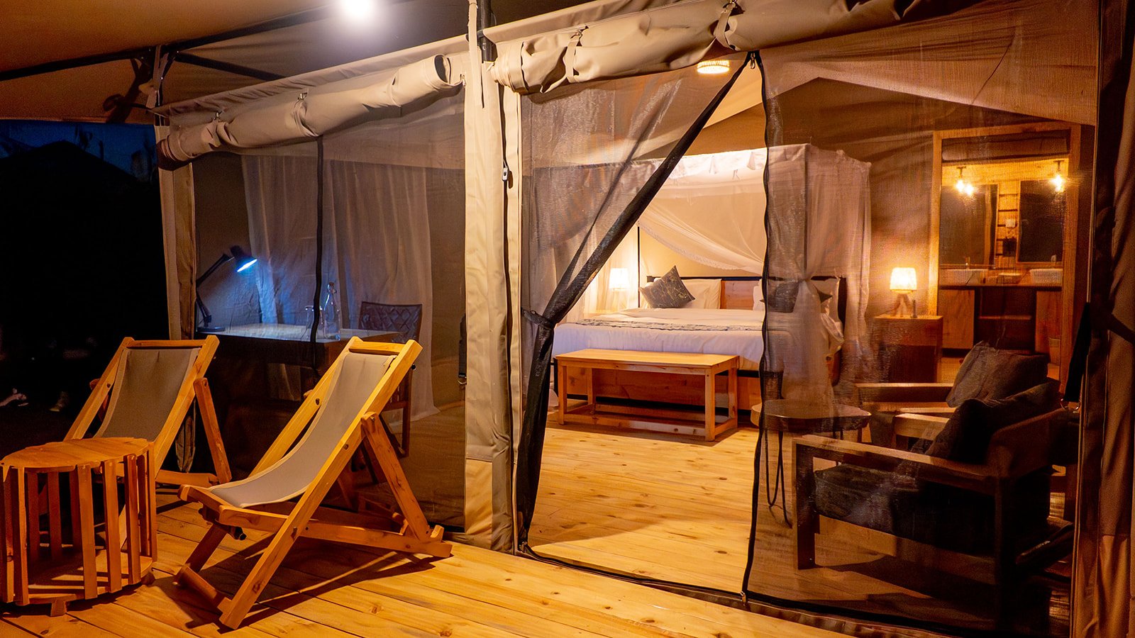 Misako Ndutu Migration Camp Zeltpavillon mit Veranda Offener Zeltpavillon mit großem Bett, Moskitonetz, Holzmöbeln und Veranda mit Klappstühlen in Tansania
