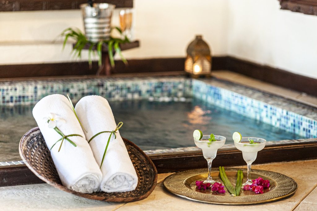 Spa-Bereich im The Palms Zanzibar mit Wasserbecken, blauen Mosaikfliesen, Handtüchern und Cocktails