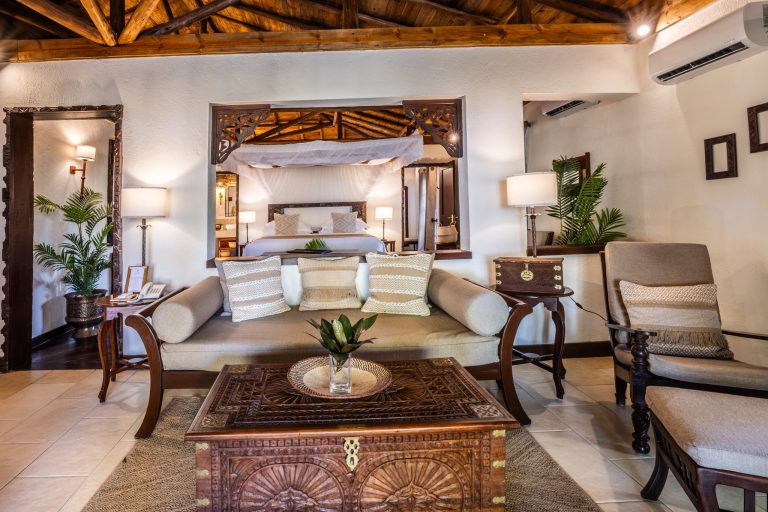 Zimmer der privaten Villa im The Palms Zanzibar mit Holzdecke, Couch, Couchtisch und Himmelbett