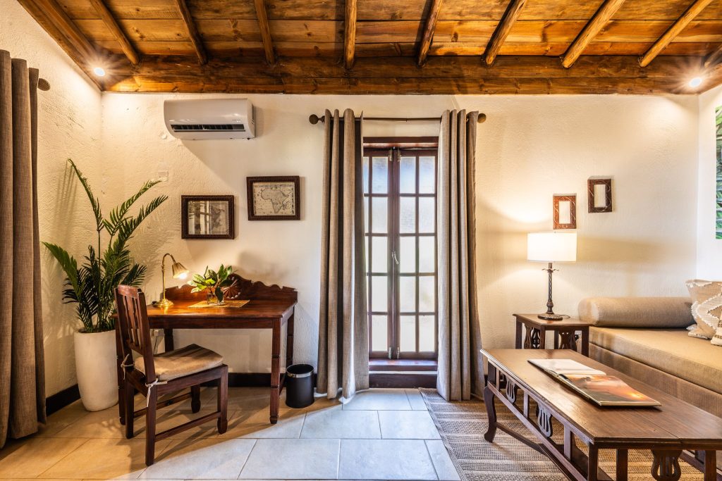 Gemütliches Zimmer der Private Villa im The Palms Zanzibar mit Holzbalkendecke, Schreibtisch, Sofa und Tageslicht