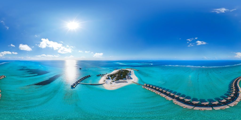 Vogelperspektive auf tropische Insel mit Wasserbungalows, weißen Sandstränden und türkisblauem Meer in den