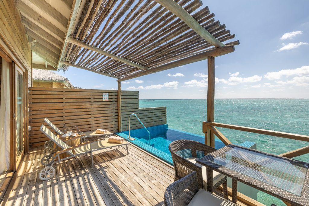 Terrasse der Aqua Suite mit Holzdeck, Liegestühlen, Infinity-Pool und Blick auf das Meer im You & Me Maldives