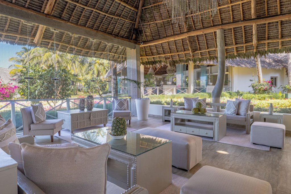 Offene Lounge des Zawadi Hotel Restaurant Drift Wood mit Holzstruktur, Palmenwedeldach und Gartenblick in Sansibar