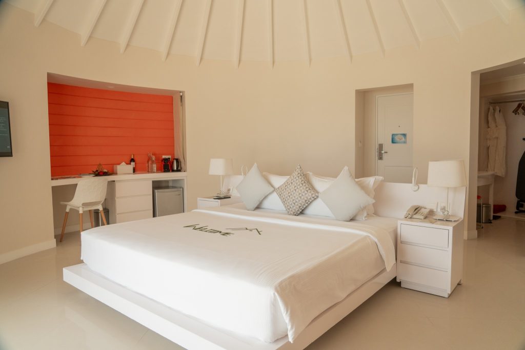 Grand Beach Villa with Pool Zimmer mit großem Bett, Minibar, Holzboden und natürlichem Licht im Sun Siyam Vilu Reef