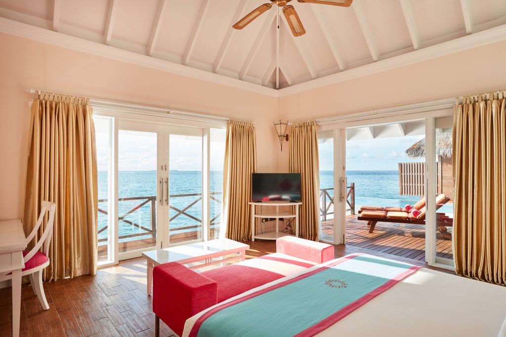 Hotelzimmer Grand Water Villa with Pool mit Bett, Holzboden, Holzventilator, zwei großen Glastüren und Meerblick auf den.